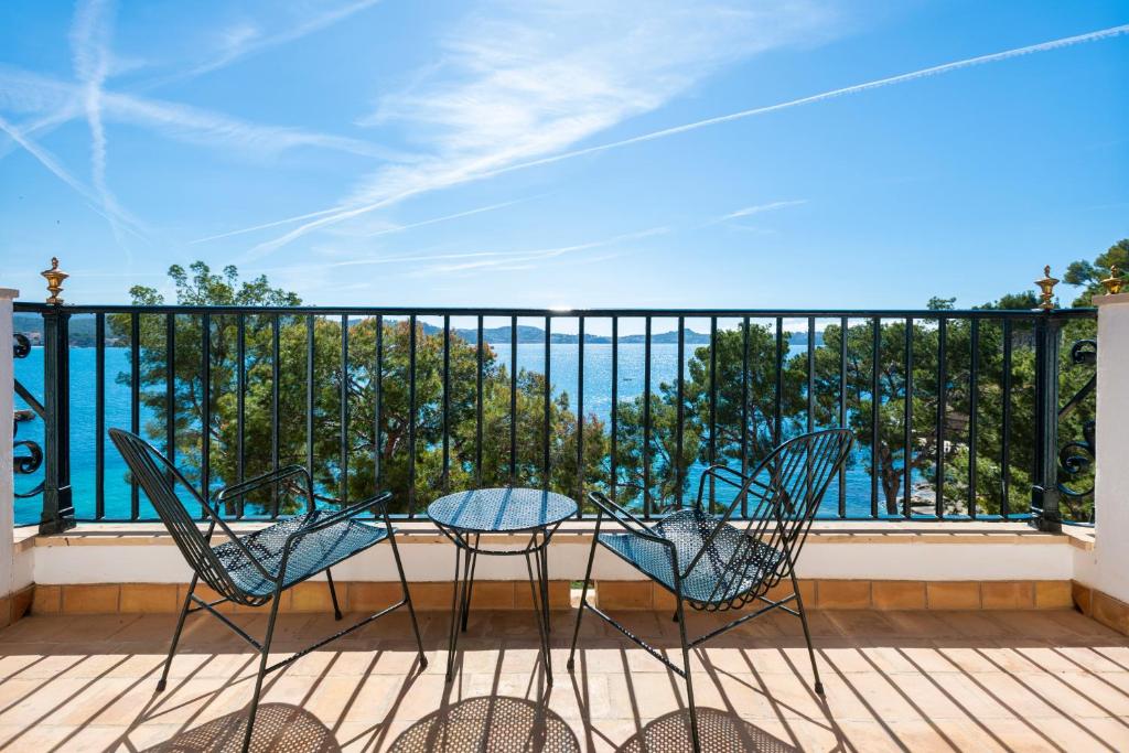 two chairs and a table on a balcony at Hotel Cala Fornells in Paguera