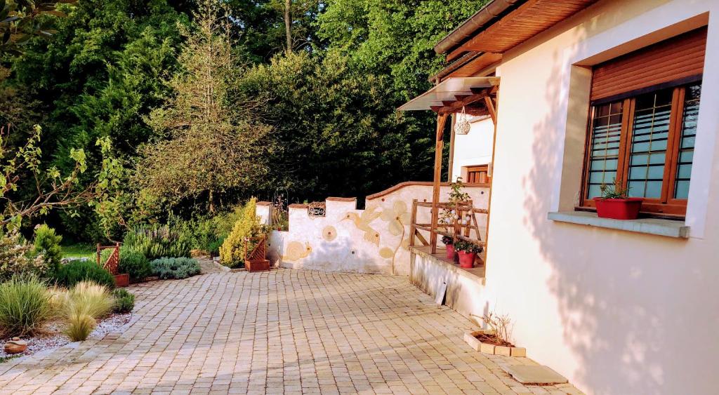 a brick walkway next to a house with trees at Studio Figues et Noix in Orchamps