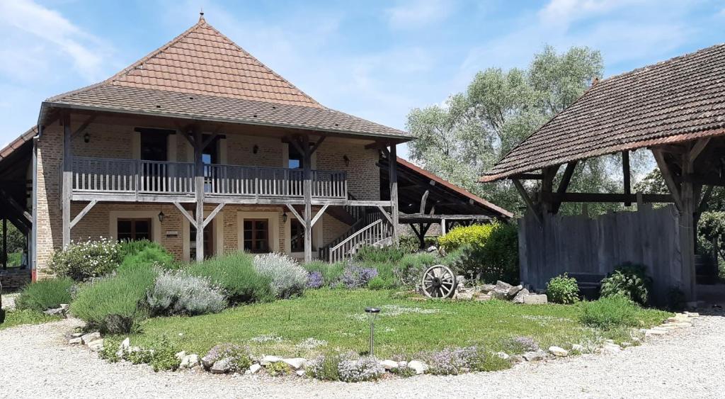 ein Haus mit einer Veranda und einem Garten davor in der Unterkunft Gîte Chez Léo in Varennes-sur-le-Doubs