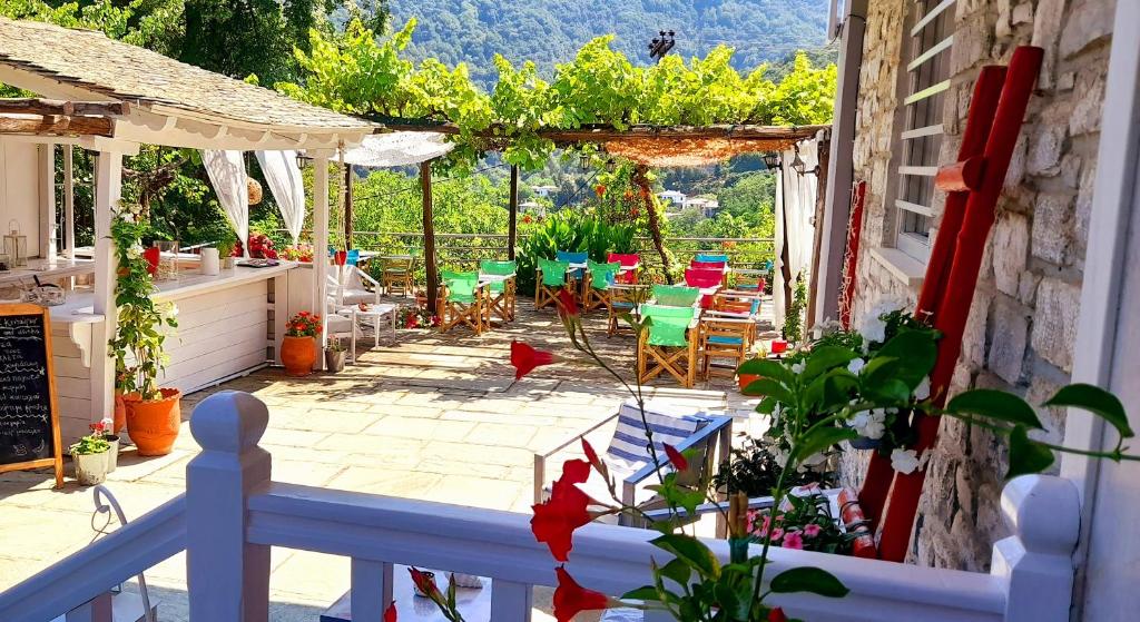 Blick auf eine Terrasse mit Stühlen und Tischen in der Unterkunft Odos Kentavron in Tsagkarada