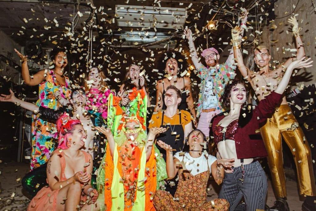 a group of people posing for a picture with confetti at GORGEOUS FlatC Central London Liverpool St Station in London