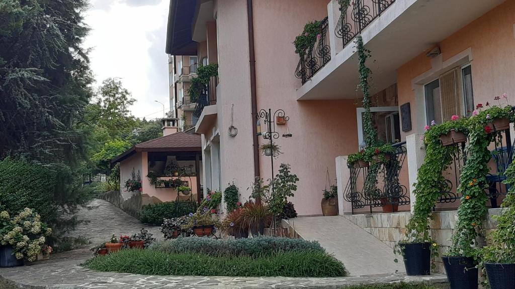 un bâtiment avec des plantes sur le côté d'une rue dans l'établissement Motivi Hotel, à Saints Constantine et Helena