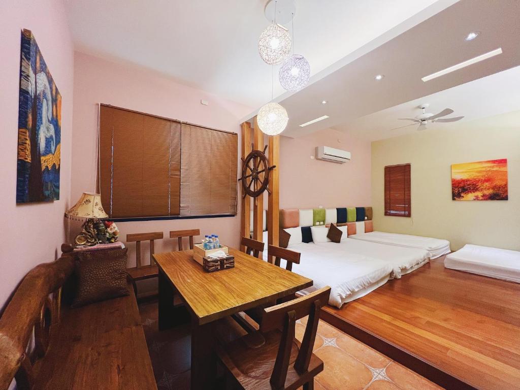 a room with two beds and a table in it at Qixingtan Xinghai B&amp;B in Dahan