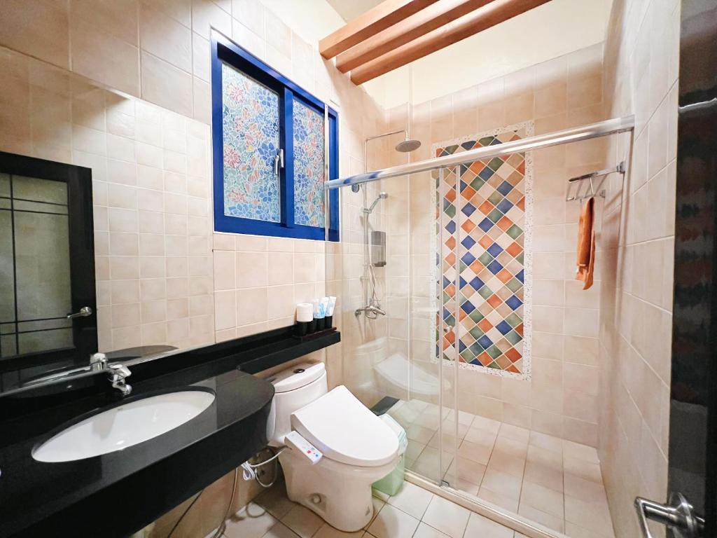 a bathroom with a toilet and a sink and a shower at Qixingtan Xinghai B&amp;B in Dahan