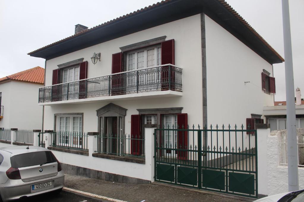 Cette maison blanche dispose de portes rouges et d'un balcon. dans l'établissement Bella Itália Casa da Universidade, à Ponta Delgada