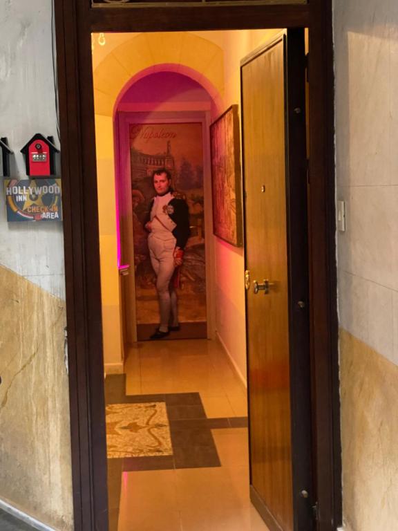 a woman is standing in the hallway of a room at Hollywood Inn Palermo in Palermo