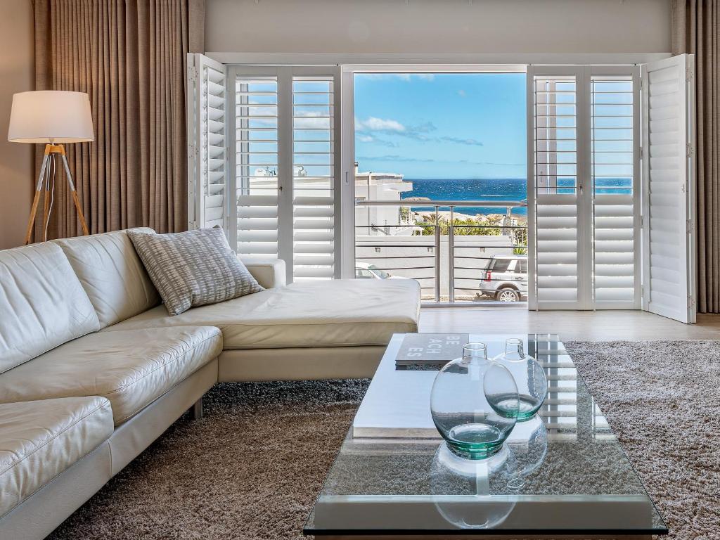 sala de estar con sofá y mesa de cristal en Blue Views Studio Apartments, en Ciudad del Cabo