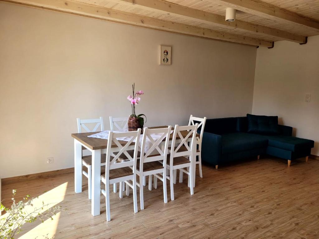 sala de estar con mesa, sillas y sofá en Domek rekreacyjny, en Odrzechowa
