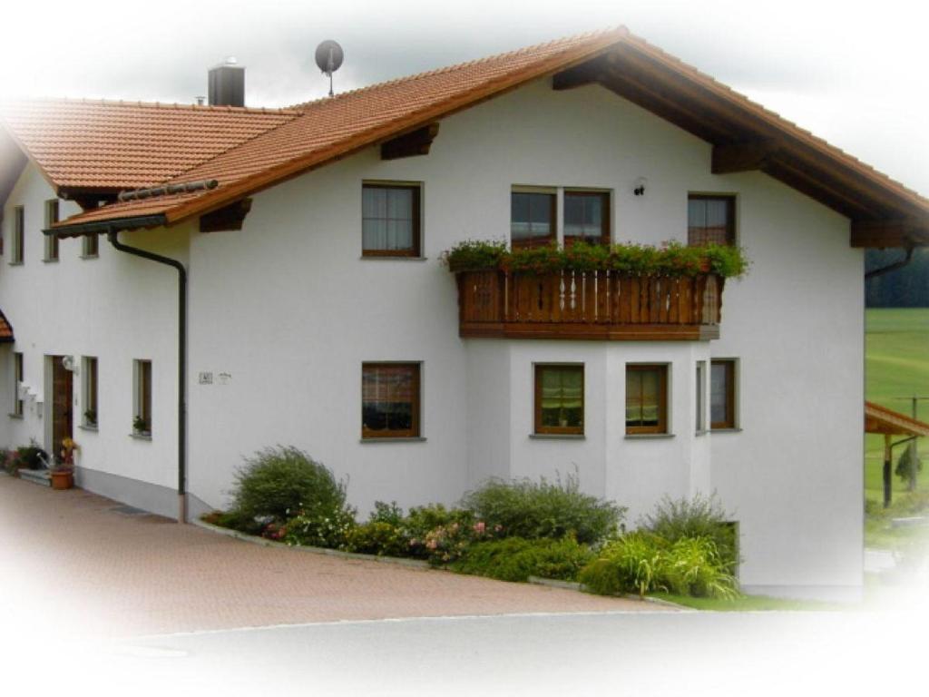 ein weißes Haus mit einem Balkon mit Pflanzen darauf in der Unterkunft Haus "Panorama" in Hohenau