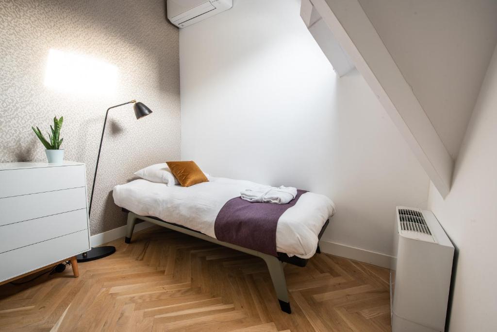 a small bedroom with a bed and a lamp at Het Lichthuis in Zandvoort