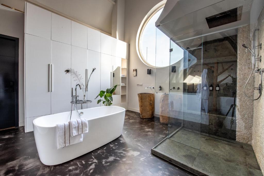 a bathroom with a white tub and a shower at Het Lichthuis in Zandvoort