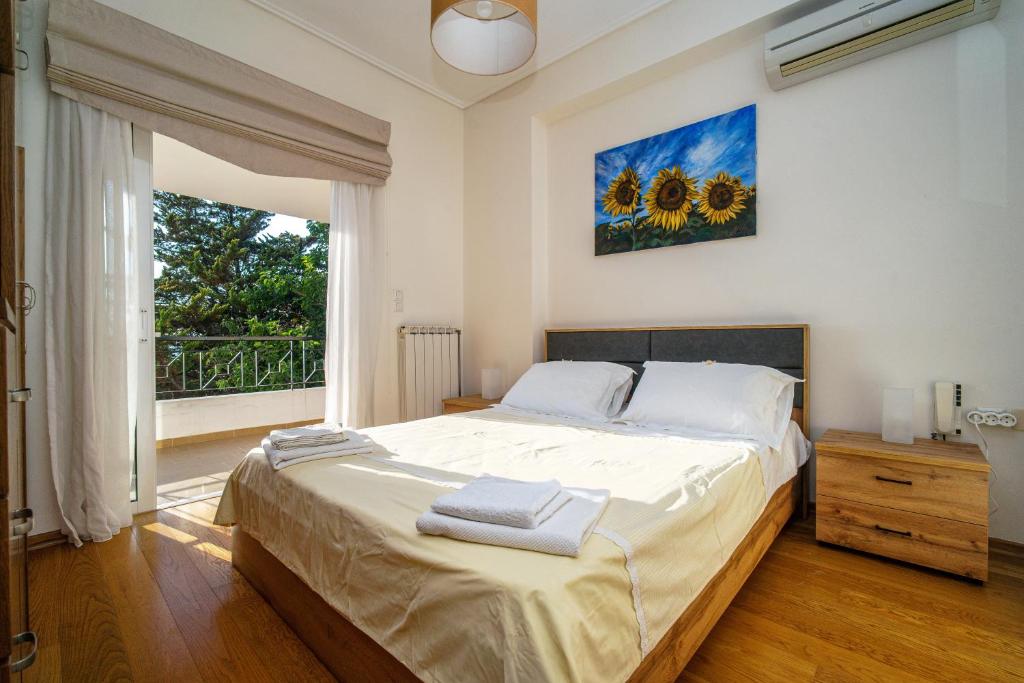 ein Schlafzimmer mit einem großen Bett und einem großen Fenster in der Unterkunft VILLA ELENI in Anavyssos