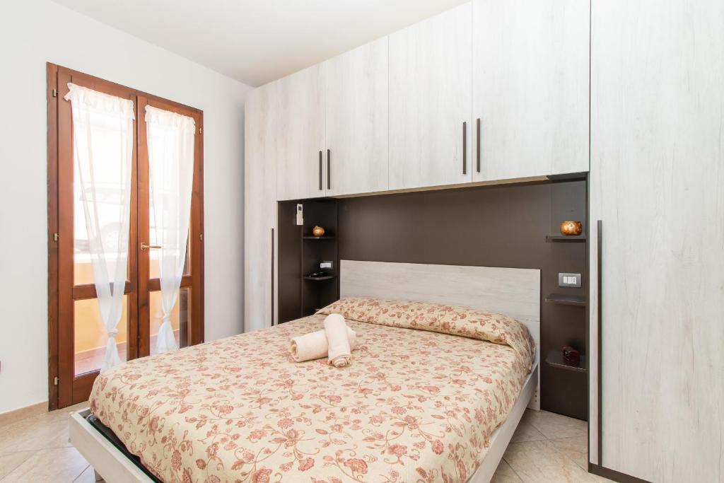 una camera da letto con un grande letto con armadi bianchi di Toderix a Castelsardo