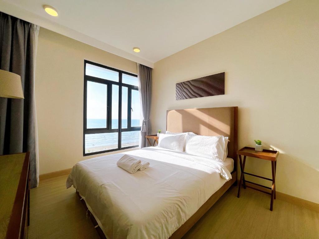 Schlafzimmer mit einem großen weißen Bett und einem Fenster in der Unterkunft Tenang Retreat at Timurbay -Full Sea View- in Kuantan