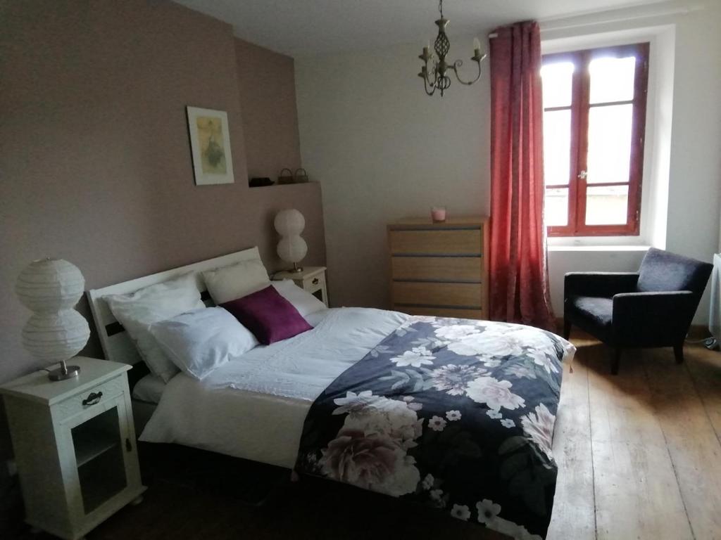 ein Schlafzimmer mit einem Bett, einem Stuhl und einem Fenster in der Unterkunft Aux douces nuits de Rivel in Rivel
