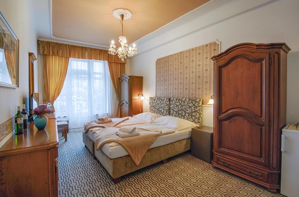 a bedroom with a large bed and a chandelier at LD Morava in Karlovy Vary