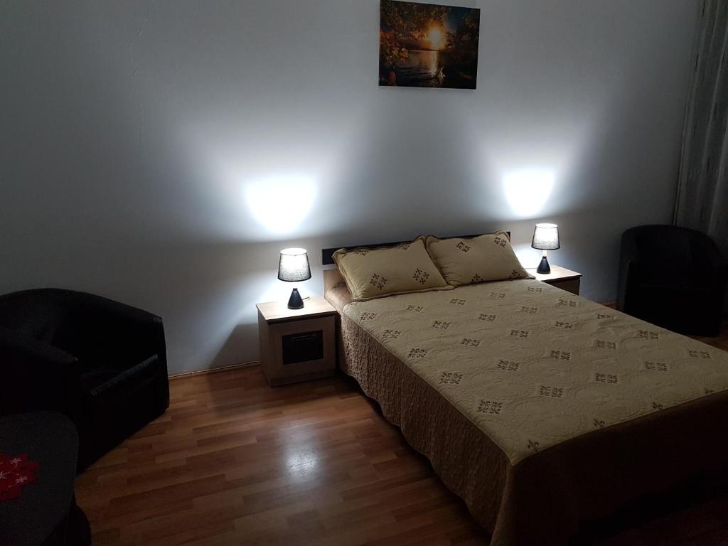 een slaapkamer met een bed en twee lampen op tafels bij Apartament YRM in Sighişoara