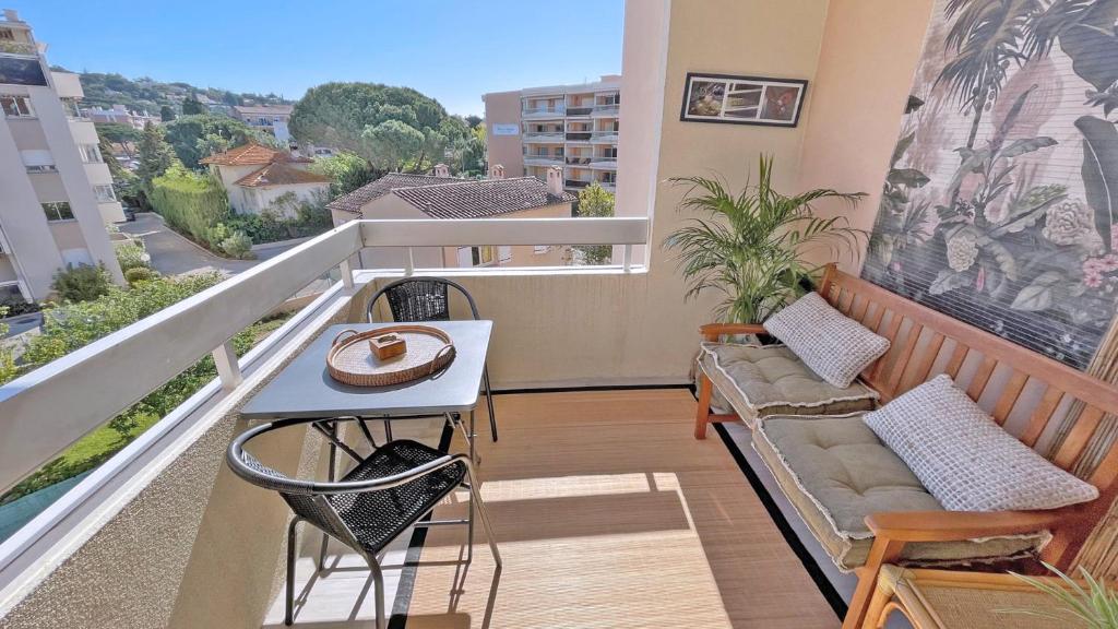 d'un balcon avec un banc et une table offrant une vue. dans l'établissement Les Coralies, à Sainte-Maxime