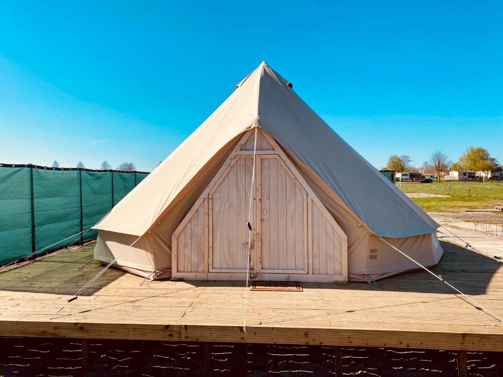 uma grande tenda situada no topo de um deque de madeira em Bell Tent em Heerewaarden