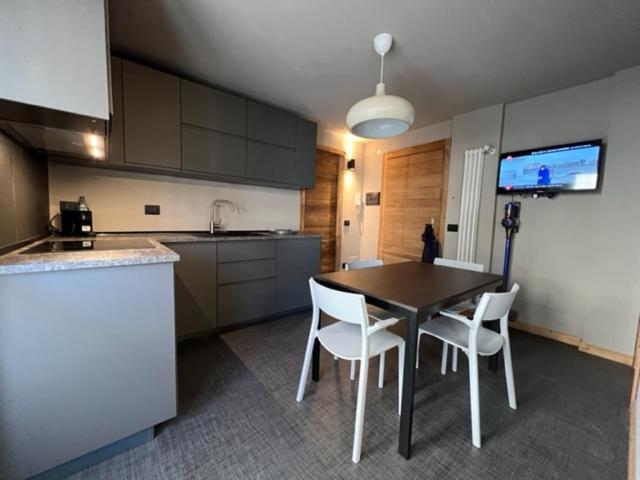 a kitchen with a table and chairs in a room at Fraiteve Suite in Sauze dʼOulx