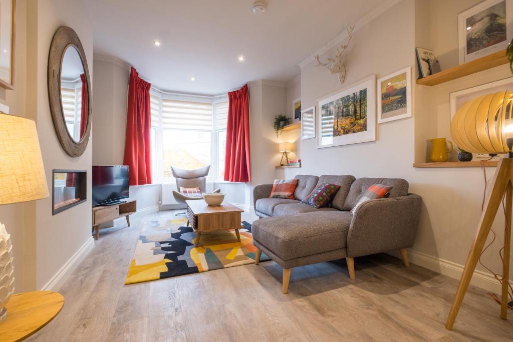 a living room with a couch and a tv at Howe Keld 1 Ground floor in Keswick