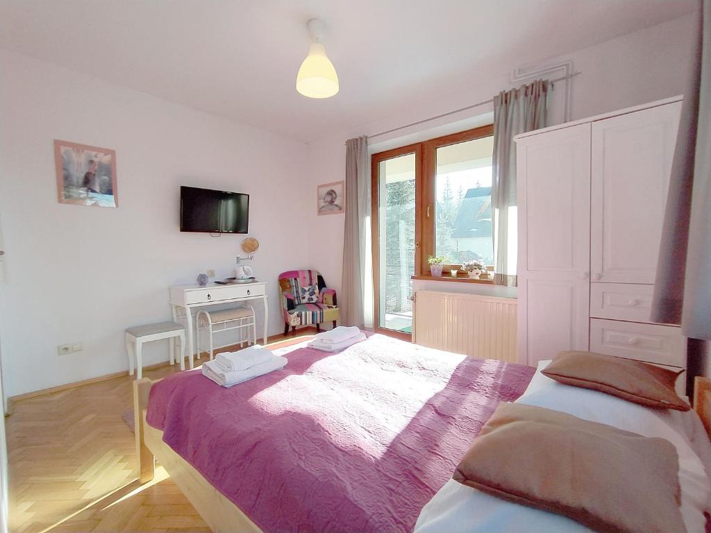 Un dormitorio con una cama grande y una ventana en Willa Mozaika, en Zakopane