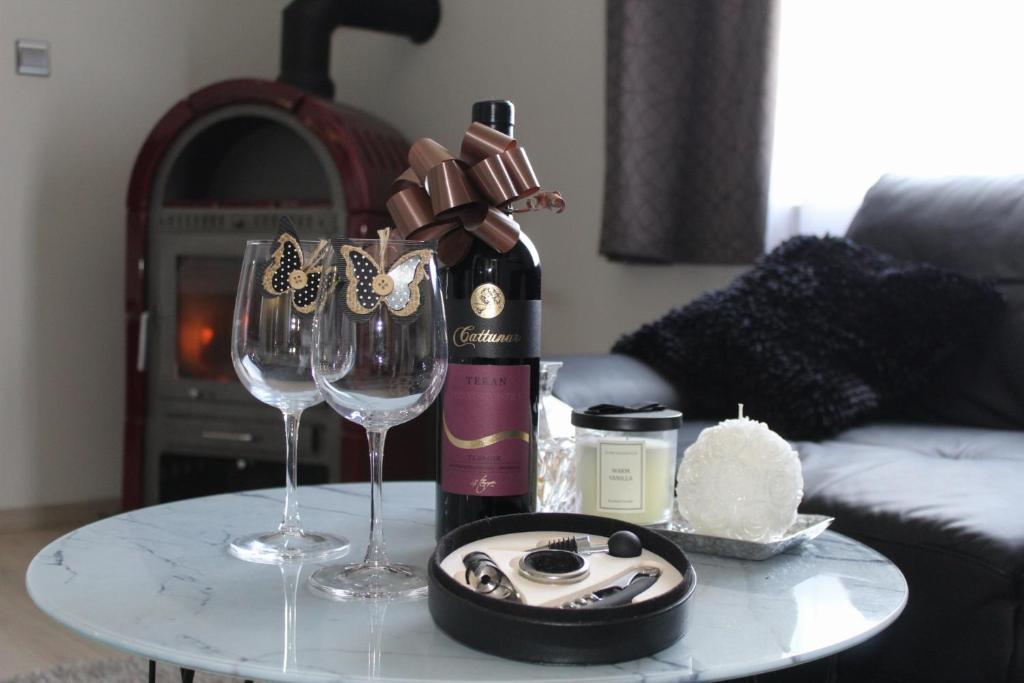 uma mesa com uma garrafa de vinho e dois copos de vinho em Apartment Dominik-Posedarje em Posedarje