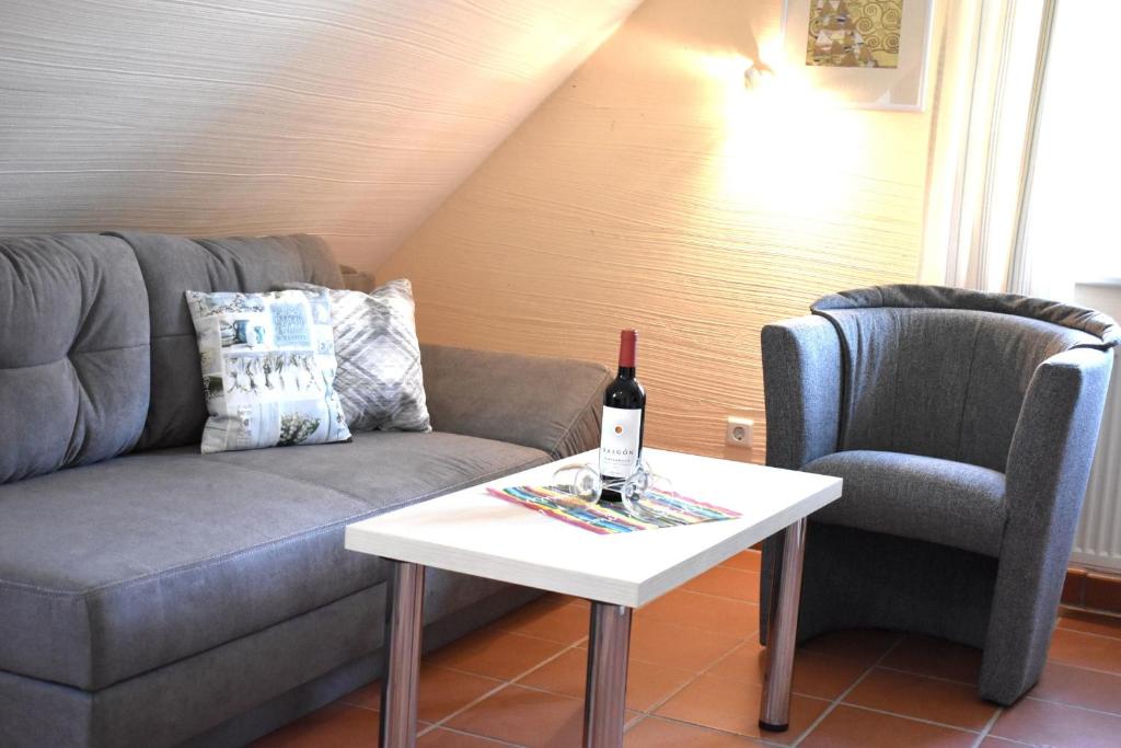a living room with a couch and a table with a bottle of wine at Ferienparadies Rugana B48 in Kreptitz
