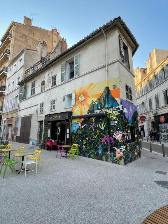 un bâtiment avec une peinture murale sur le côté dans l'établissement LaFrenchCasa La Plaine, à Marseille
