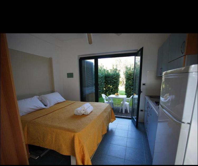 1 dormitorio con 1 cama con 2 toallas en Nel villaggio il Monolocale tra gli ulivi, en SantʼAndrea Apostolo dello Ionio