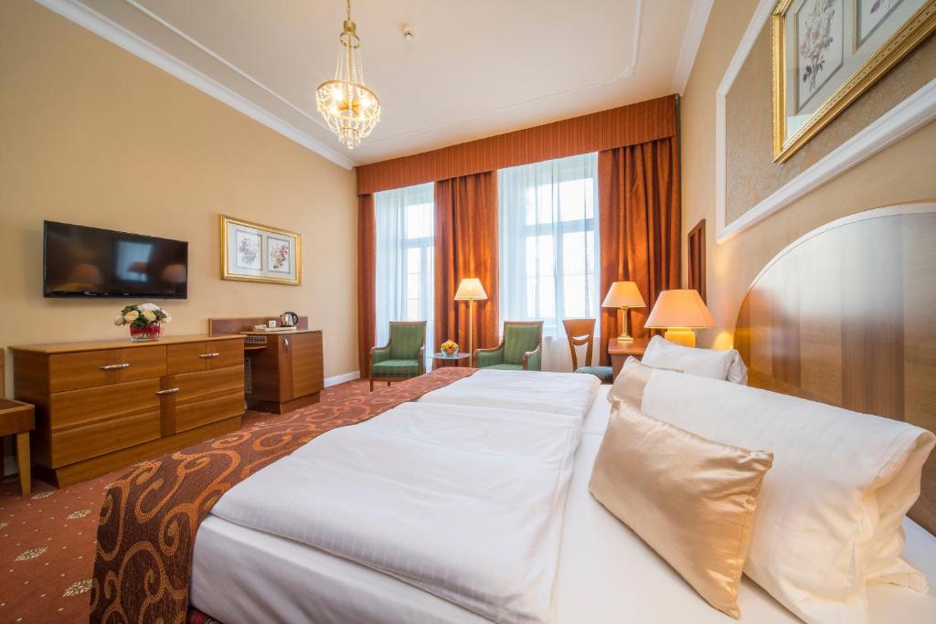 a hotel room with two beds and a television at Spa Resort PAWLIK-AQUAFORUM in Františkovy Lázně