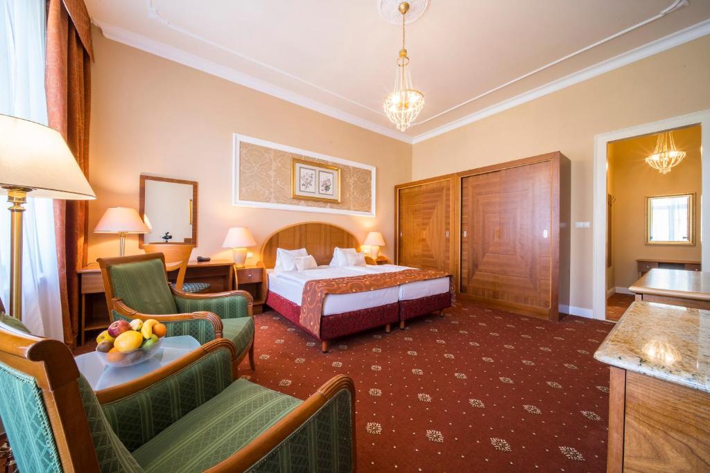 a hotel room with a bed and two chairs at Spa Resort PAWLIK-AQUAFORUM in Františkovy Lázně