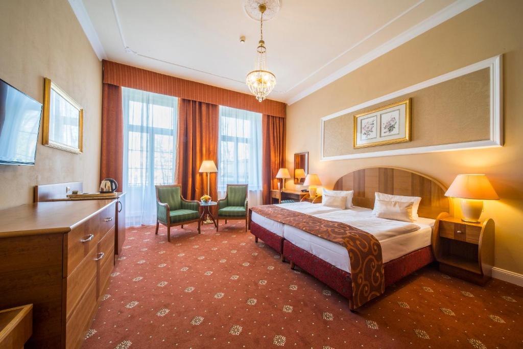 a hotel room with a bed and a desk at Spa Resort PAWLIK-AQUAFORUM in Františkovy Lázně