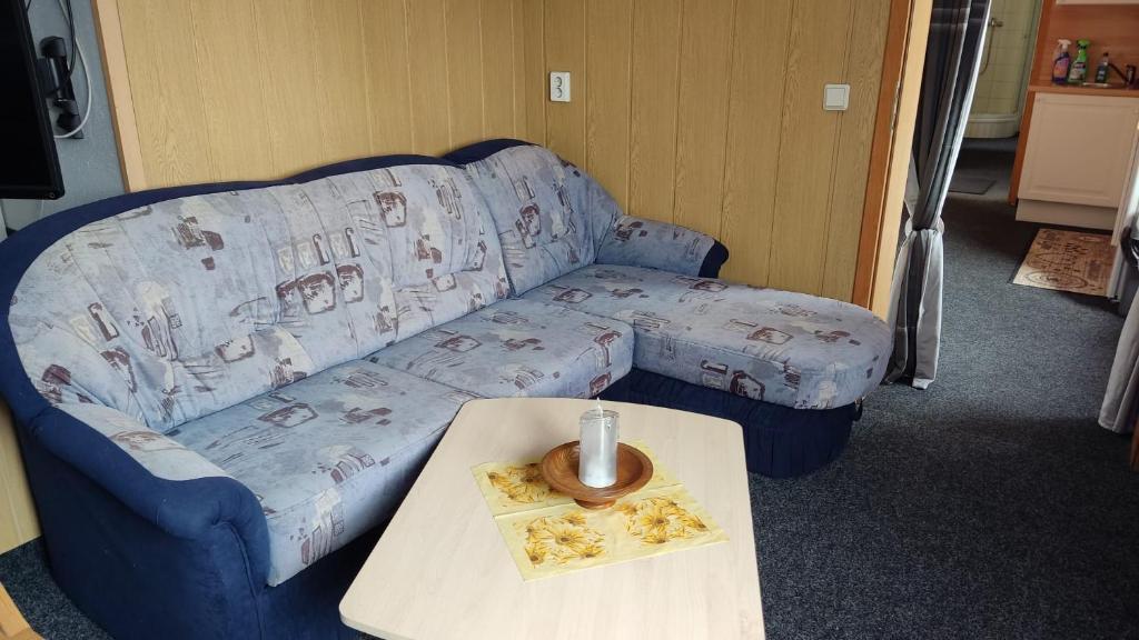 a living room with a blue couch and a table at Ferienwohnung in Rathenow in Rathenow