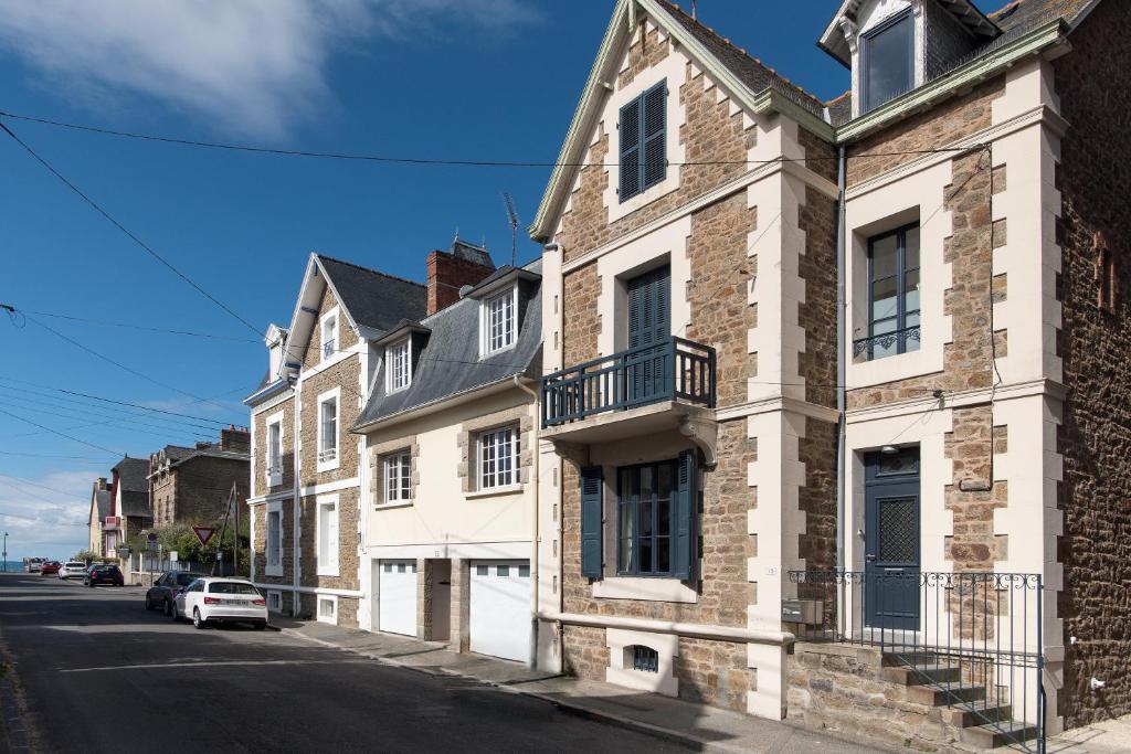 eine Reihe von Häusern auf einer Straße mit einem Auto in der Unterkunft Villa Jules Simon in Saint-Malo