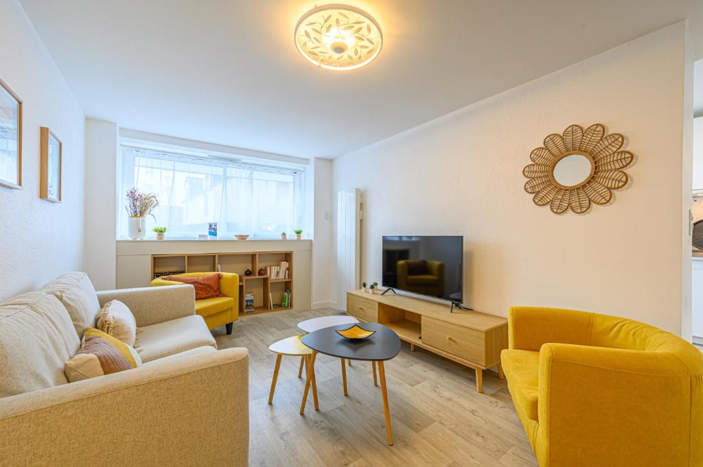 a living room with a couch and a tv at Le Krisco, une maisonnette en cœur de ville avec un parking privé in Vannes