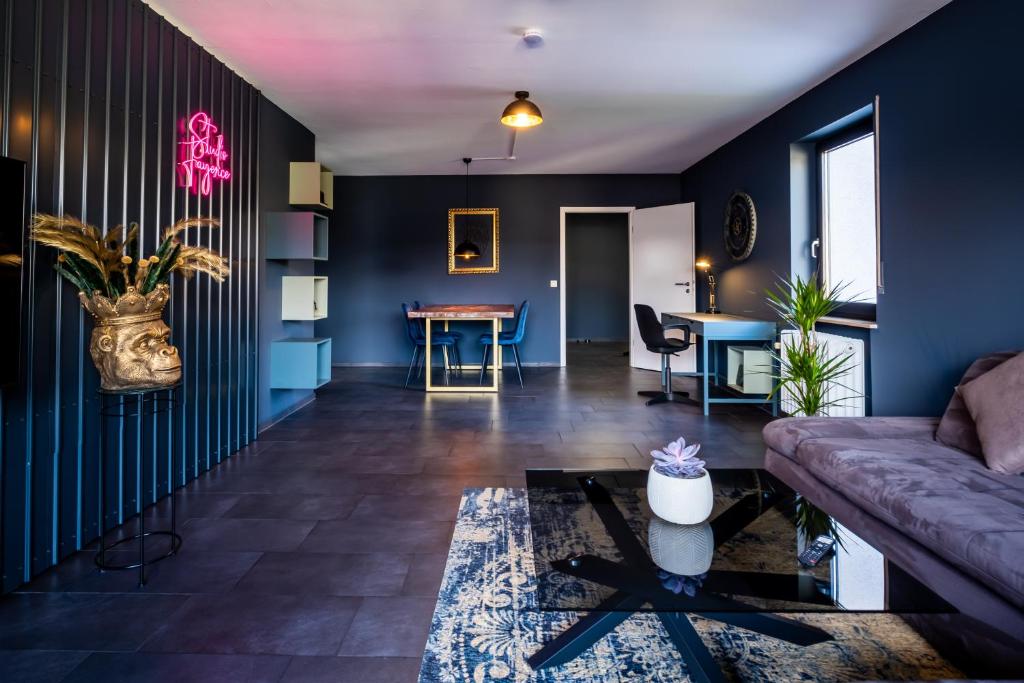 un soggiorno con pareti blu e divano di Studio Fayence - EMMA, Netflix, WiFi, Workspace a Karlsruhe