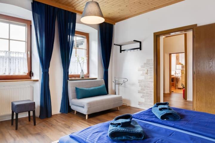 - une chambre avec un lit bleu et une chaise dans l'établissement Vanek Apartment, à Mauthen