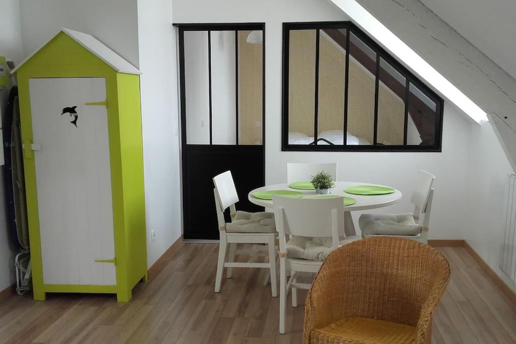une salle à manger avec une table et des chaises et une fenêtre dans l'établissement Le Petit Bé, à Saint-Malo