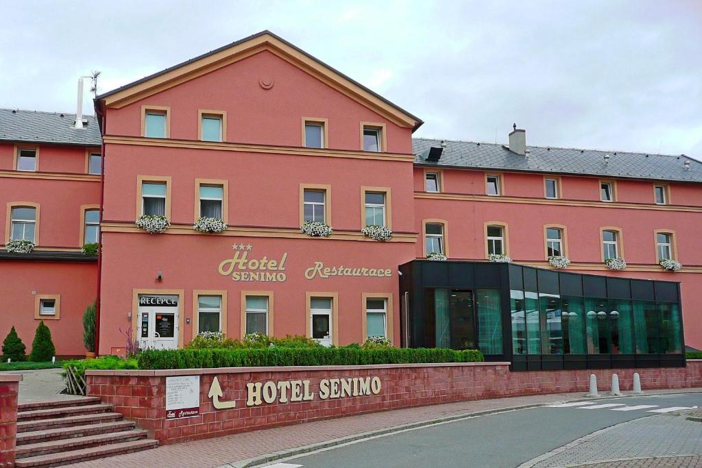 オロモウツにあるHotel Senimoのホテルが目の前にある大きなピンクの建物