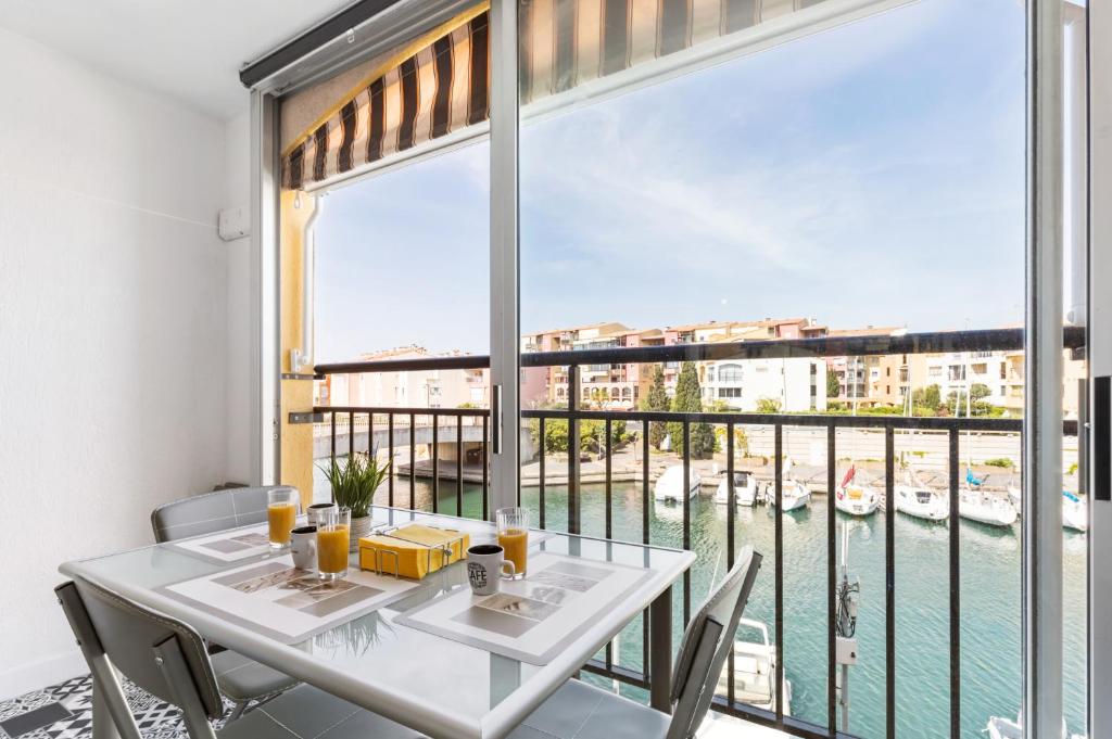 une salle à manger avec une table et une grande fenêtre dans l'établissement Little Venezia by POM, au bord de l'eau, parking, au Cap d'Agde
