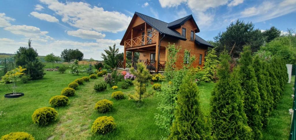 una casa con un jardín delante de ella en Domek Chańcza, en Chańcza