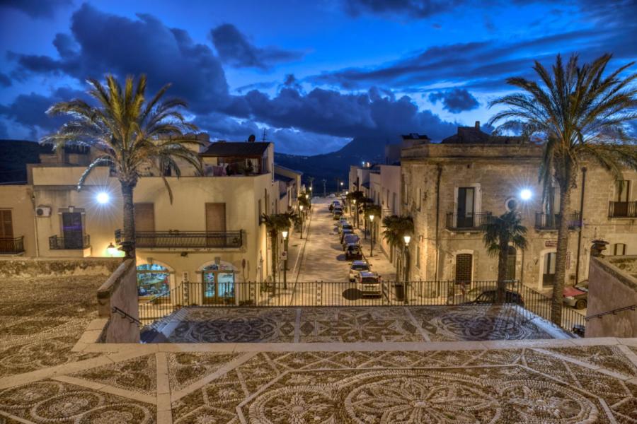 una calle de la ciudad por la noche con palmeras y edificios en a casa di Dina, en Purgatorio