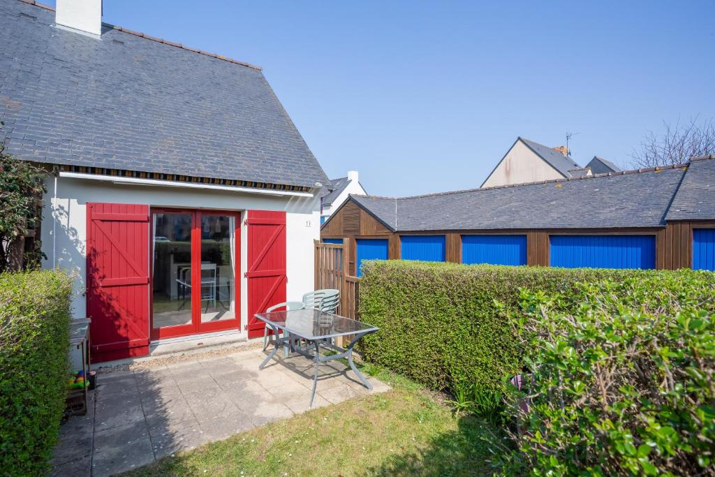 ein Haus mit einer roten Tür und einer Terrasse in der Unterkunft La maisonnette malouine in Saint-Malo