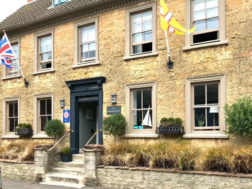 a stone building with flags in front of it at The Bridge House in Bridport