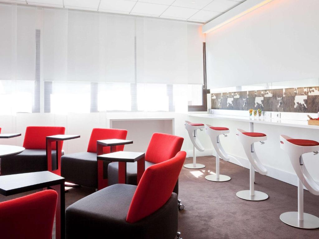 a waiting room with red chairs and a bar at Novotel Marseille Vieux Port in Marseille