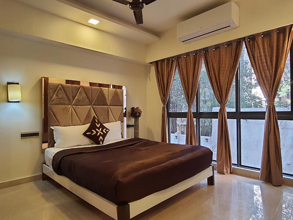 a bedroom with a bed and a large window at OSI Apartments BKC Kurla West in Mumbai