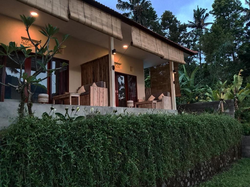 ein Haus mit einer Hecke davor in der Unterkunft Abian Dauh Sidemen in Karangasem