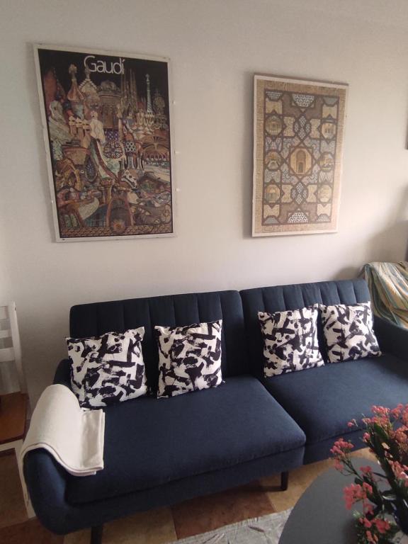 a blue couch sitting in a living room with pillows at Precioso apartamento con aparcamiento gratuito in Purchil