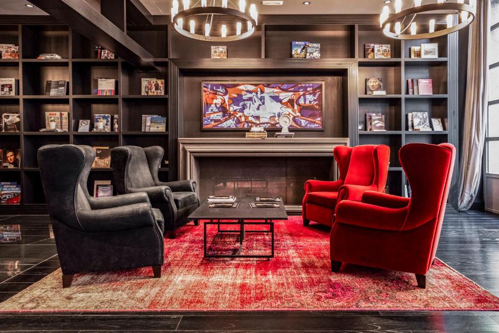 a living room with two red chairs and a tv at Palazzo Cornalia in Milan